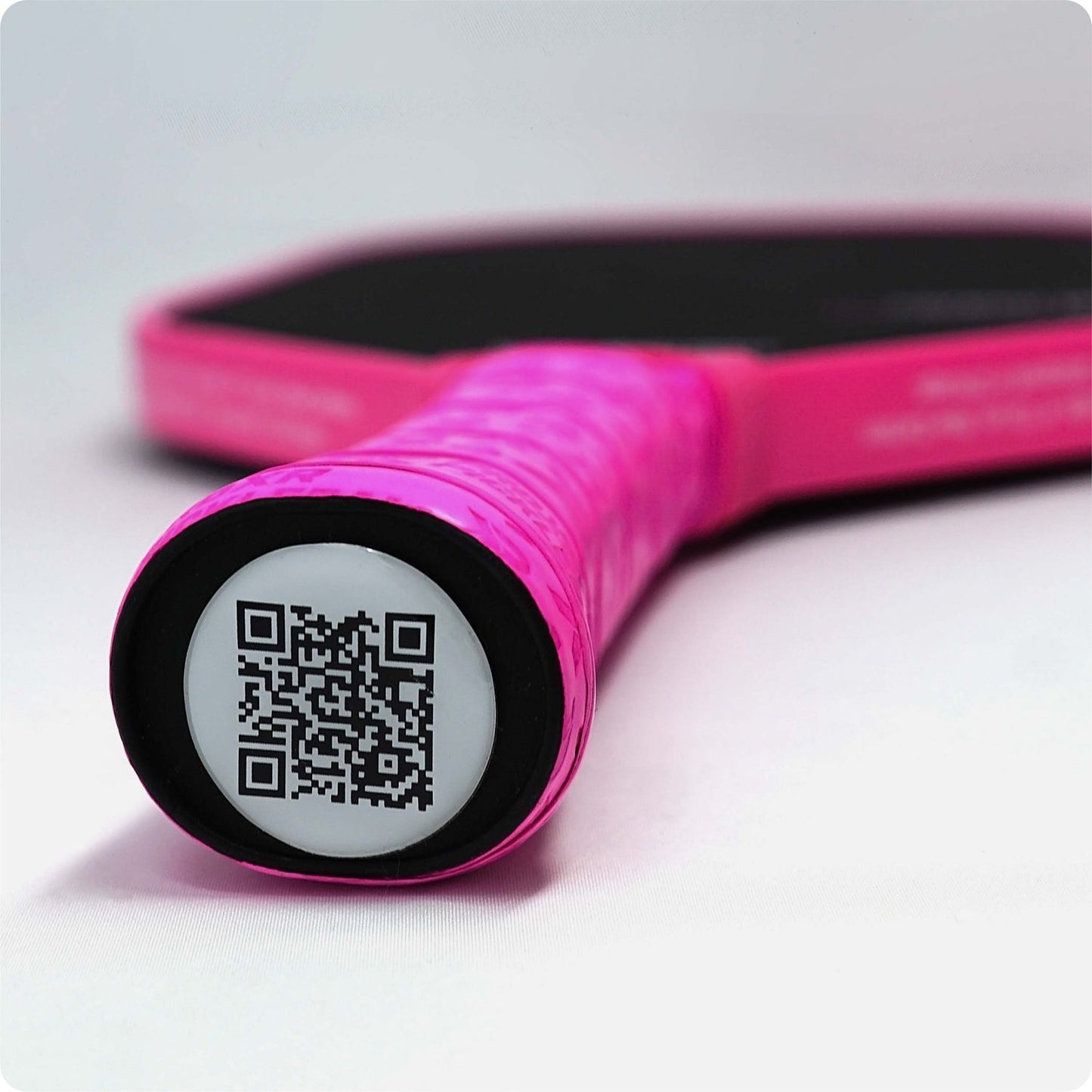 Pink pickleball paddle handle detail, featuring a QR code.