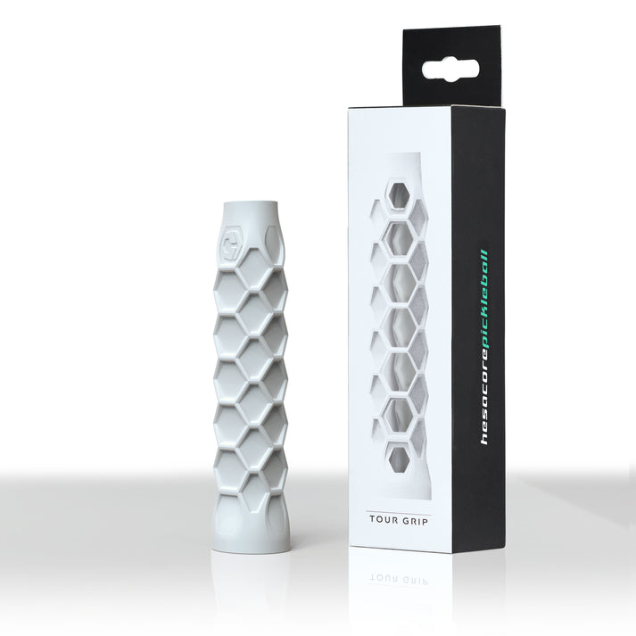 White pickleball paddle grip with hexagonal design, shown in its packaging.