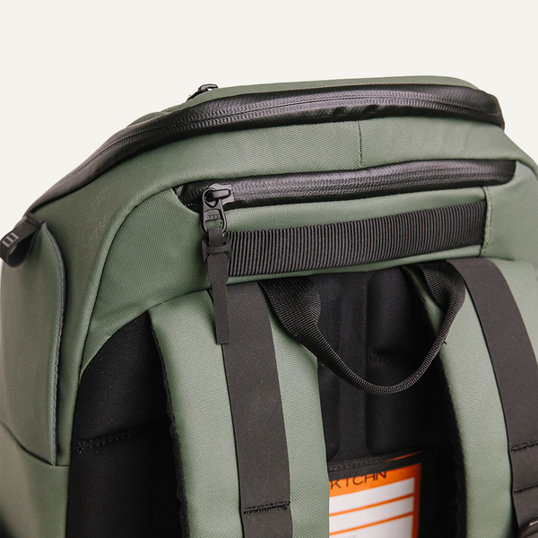 Close-up of olive green pickleball backpack's top zipper and padded straps.