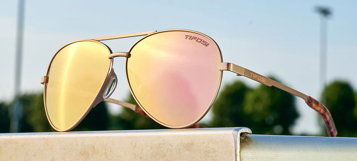 Rose gold aviator sunglasses with pink mirror lenses, outdoors.