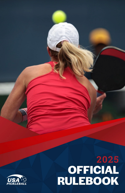 Woman in red shirt playing pickleball, back view.