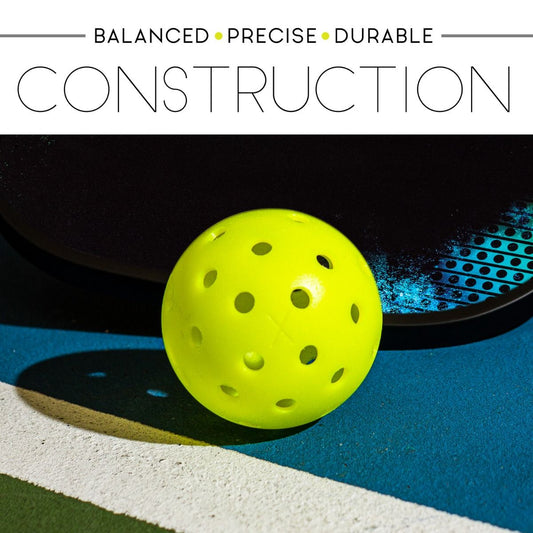 Franklin X-40 outdoor pickleball next to a paddle on a teal court for an indoor vs outdoor pickleballs guide at Get2Eleven