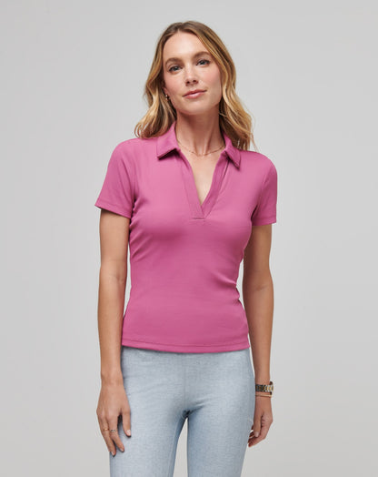 Ribbed v-neck pink polo shirt on a model, casual studio setting
