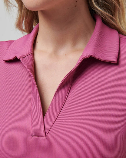 Close-up of a ribbed, mauve V-neck polo shirt collar.
