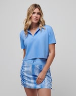 Travis Mathew Deco District Polo: Light blue, short-sleeve, cropped polo shirt for women.
