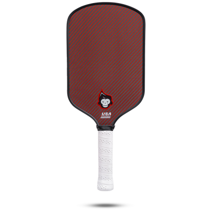 Pickleball paddle with red and gray carbon fiber face, white grip.
