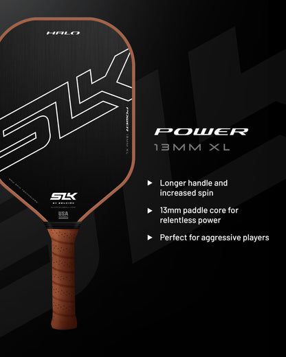 Black pickleball paddle with a brown grip, highlighted against a dark background.
