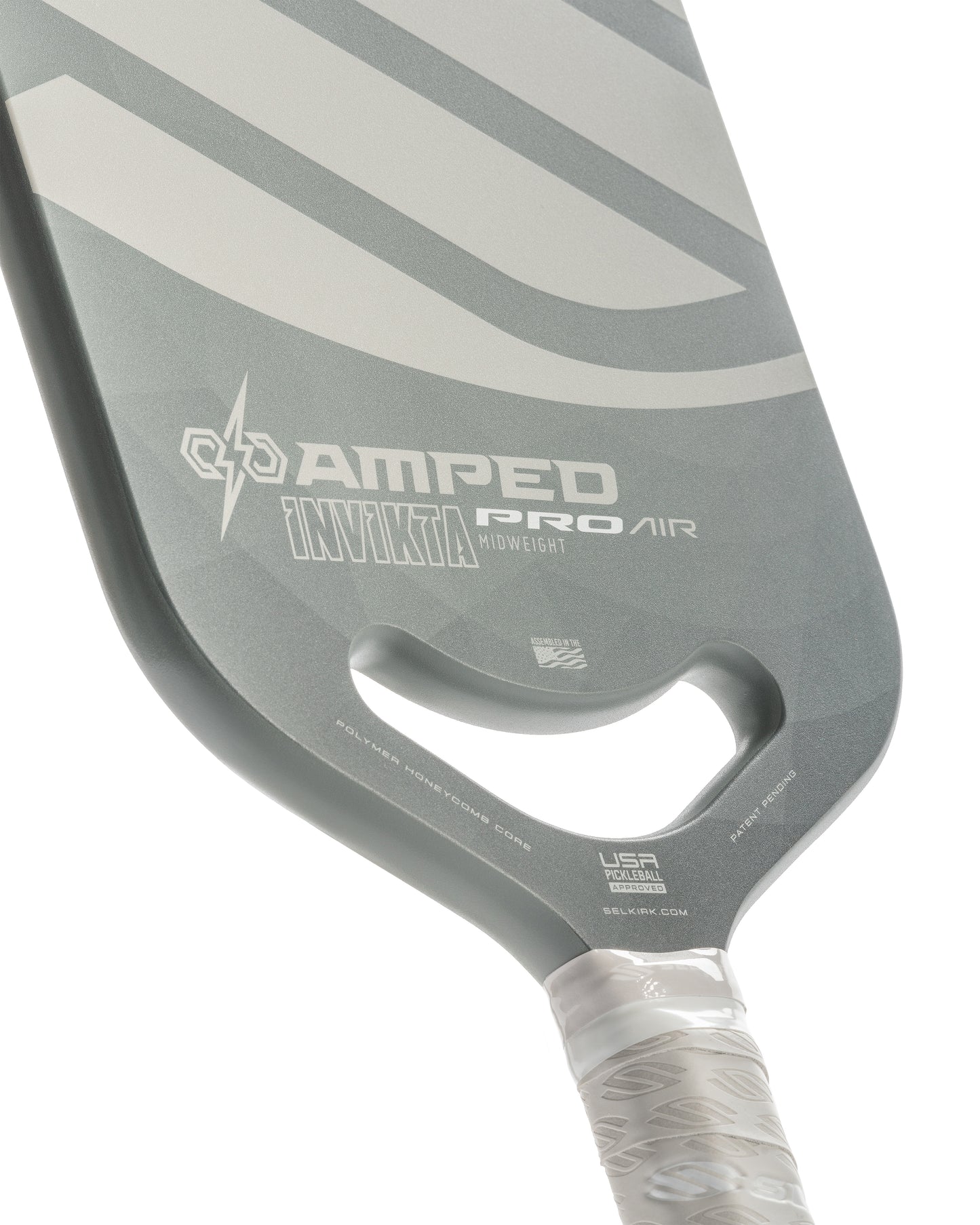 Close-up of a gray pickleball paddle with white accents, showcasing its lightweight design and polymer honeycomb core.
