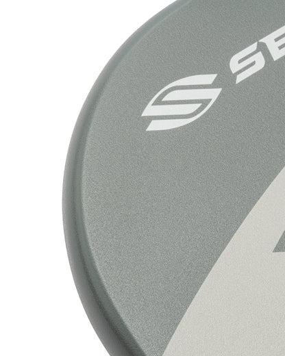 Close-up of a gray pickleball paddle's textured surface and logo detail.
