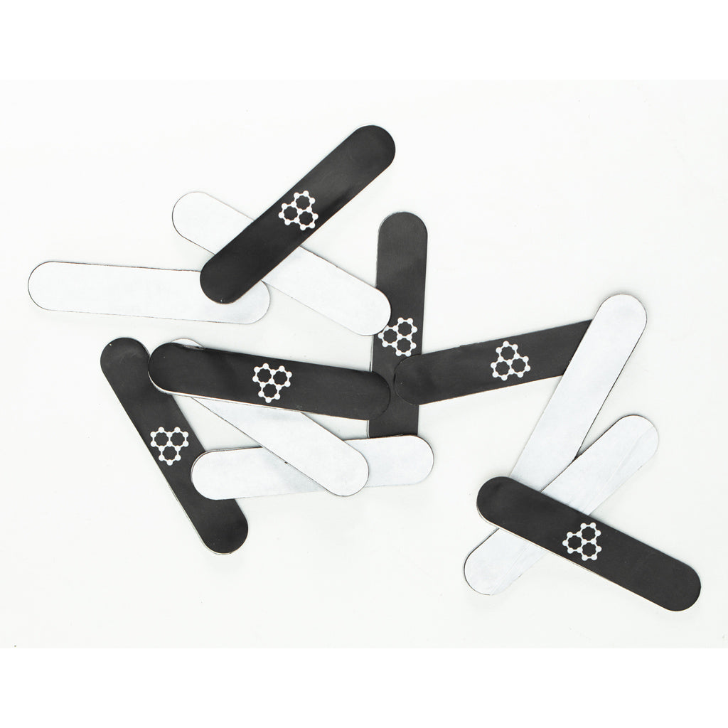 Black and white lead tape strips scattered on a white background.
