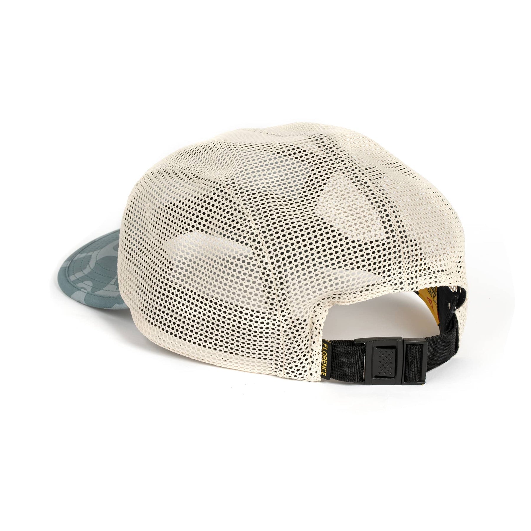 Cream-colored unstructured hat with mesh back, adjustable black strap, and a camouflage-patterned brim.
