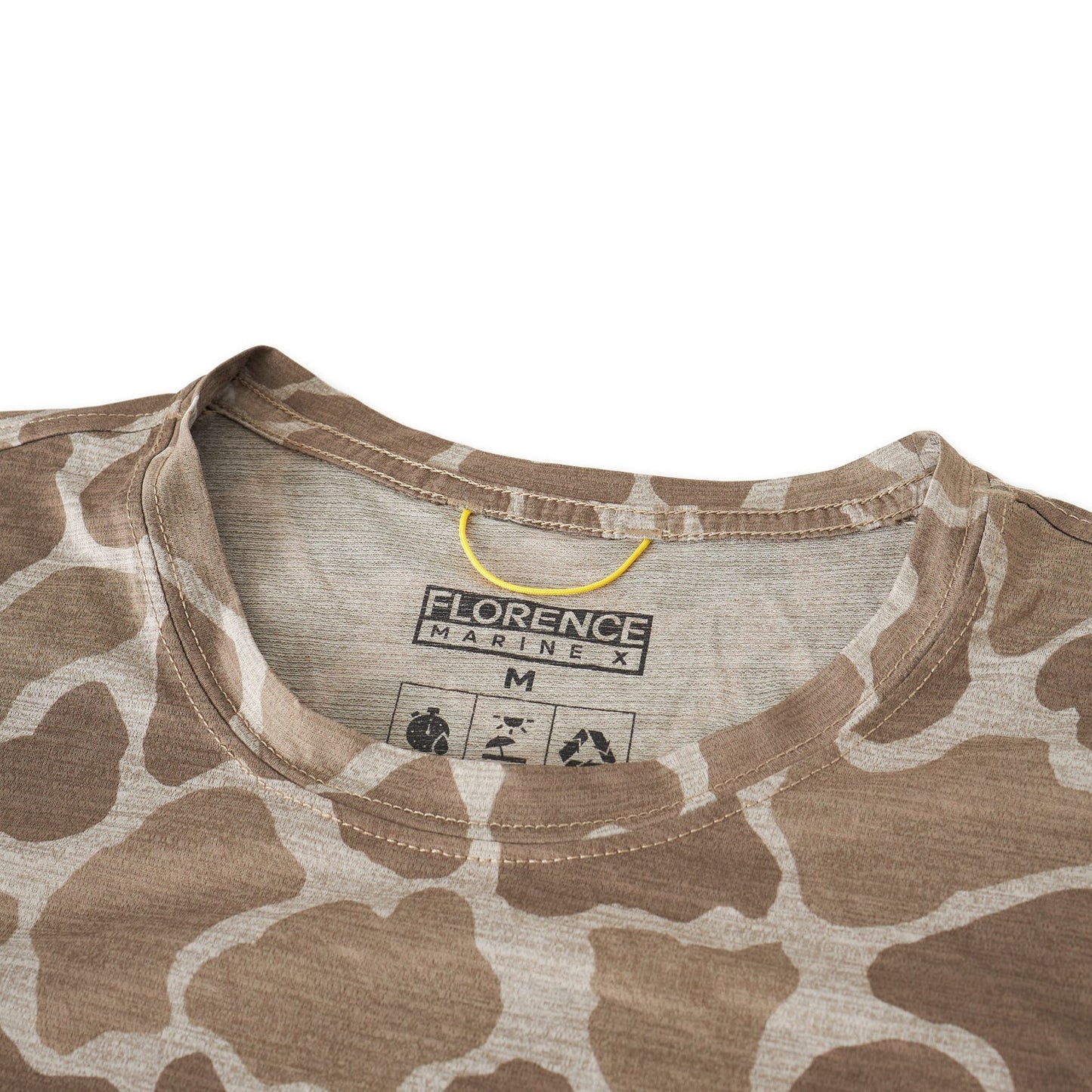 Close-up of a beige long-sleeve shirt with a unique animal print, showcasing a size small tag.
