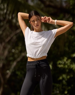 Travis Mathew Silver Spray Top: White cropped athletic top with cinched waist, perfect for workouts or casual wear.
