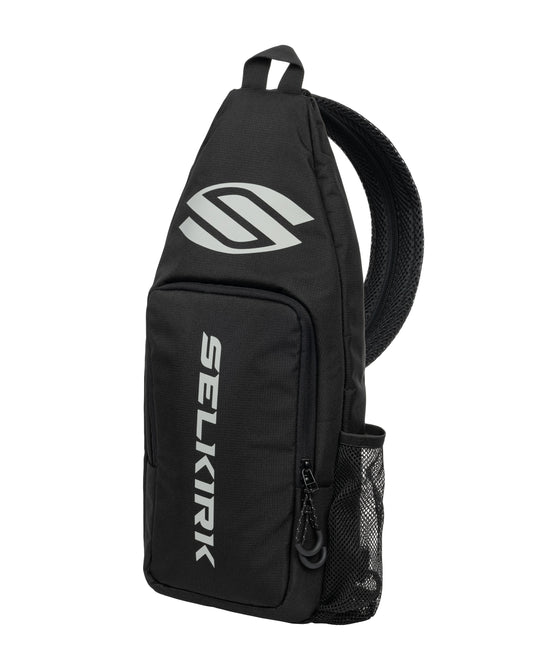 Selkirk Core Line Pickleball Sling Bag: Black polyester crossbody bag with reflective logo & mesh pocket.
