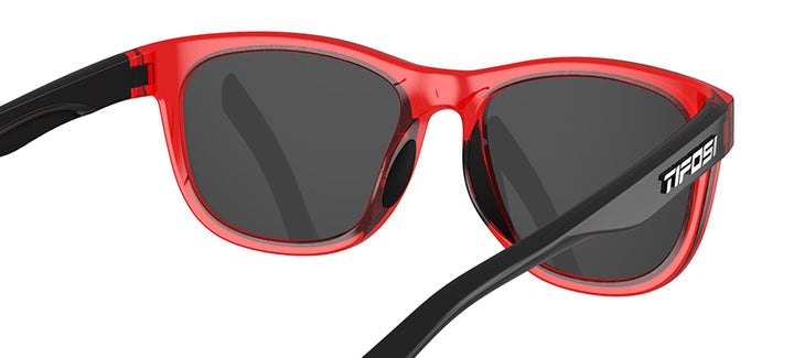 Red translucent sunglasses with dark gray lenses and black temples.
